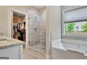 Bathroom featuring a soaking tub, a glass-enclosed shower, and a large walk-in closet at 234 Thyme Leaf Way, Locust Grove, GA 30248