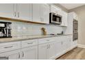 Modern kitchen featuring white cabinets, granite countertops, and stainless steel microwave at 234 Thyme Leaf Way, Locust Grove, GA 30248
