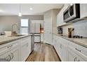 Bright kitchen featuring white cabinets, granite countertops, and stainless steel appliances at 234 Thyme Leaf Way, Locust Grove, GA 30248
