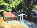 Aerial view of a charming brick home showcasing its covered front porch and driveway at 1150 Goldsmith Rd, Stone Mountain, GA 30083