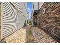Side view of a townhome with a stone facade and pea gravel walkway to a black front door at 1058 Kirkland Cir, Smyrna, GA 30080