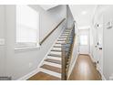 Bright entryway featuring a staircase with wooden handrail and hardwood floors at 1058 Kirkland Cir, Smyrna, GA 30080