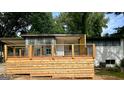 Charming home featuring a new wooden deck with black metal railings at 6072 Holiday Blvd, Forest Park, GA 30297