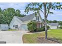 Rear exterior view of home showing backyard and attached garage at 1108 The By Way, Mcdonough, GA 30252