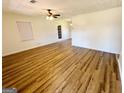 Bright living room featuring wood-look flooring, a ceiling fan, and a glass paneled back door at 36 Reese St, Grantville, GA 30220