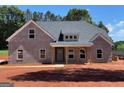 New construction featuring a gray brick exterior, covered front porch and professionally landscaped yard at 1705 Lake Dow Rd, Mcdonough, GA 30252