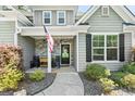 Inviting front porch with stone accents, rocking chairs, and an American flag display at 130 Edgewater Trl, Fayetteville, GA 30215