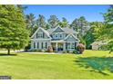 Charming two-story home with beautiful landscaping, well manicured lawn, and inviting front porch at 130 Edgewater Trl, Fayetteville, GA 30215