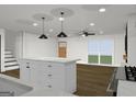 Bright kitchen with white cabinets, stone countertops, stainless appliances, stylish pendant lighting, and hardwood floor at 4274 Kimball Sw Rd, Atlanta, GA 30331