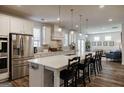 Modern kitchen with stainless steel appliances, white cabinets, and a large center island with seating at 7435 Ansley Park Way, Cumming, GA 30028