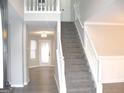 Bright foyer features beautiful staircase and wood flooring that leads to a glass-paneled back door at 7564 Mountain Ridge Ln, Lithonia, GA 30058