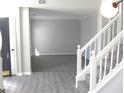 Open-concept living room view from the stairs, featuring neutral paint and plush carpeting at 7564 Mountain Ridge Ln, Lithonia, GA 30058