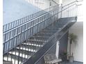 A staircase with metal railings leads to upper-level condos and a small outdoor seating area at 4000 Orchard Hill Ter, Stone Mountain, GA 30083