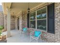 Inviting front porch with chairs, decorative pillows, and a hanging light fixture at 171 Osier Dr, Mcdonough, GA 30252