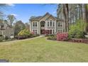 This large home has mature trees, colorful azaleas, and a sprawling green lawn at 1000 Pleasance Grv, Peachtree City, GA 30269