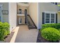 Exterior shot of condo building with staircase leading to upper units, surrounded by greenery at 606 Ridgelake Dr, Peachtree City, GA 30269
