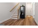 A view of the entryway with a hardwood floor, a staircase, and a cabinet at 823 Mackay Crk, Woodstock, GA 30188