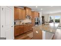 A view of the kitchen with wooden cabinets, stainless steel appliances, and granite countertops at 823 Mackay Crk, Woodstock, GA 30188