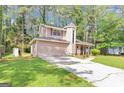 Charming two-story home with a unique turret and an attached two-car garage nestled among mature trees at 916 Forest Pointe, Jonesboro, GA 30238