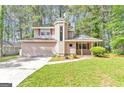 Charming two-story home with a unique turret and an attached two-car garage nestled among mature trees at 916 Forest Pointe, Jonesboro, GA 30238