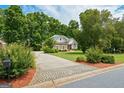 Attractive home with a long driveway and well-maintained landscaping, set back from the road with mature trees at 115 Blue Grass Way, Oxford, GA 30054