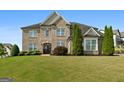 Stunning brick home with a meticulously manicured lawn and lush landscaping, exudes curb appeal and timeless elegance at 1516 Winward Dr, Locust Grove, GA 30248