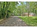 Long driveway leading to a single-Gathering home surrounded by mature trees at 152 Dana Dr, Fayetteville, GA 30215