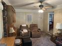 Cozy living room featuring plush recliners, wood-paneled walls, and a ceiling fan for comfort at 4884 Maurice Nw Dr, Lilburn, GA 30047