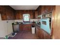 Vintage kitchen featuring wood cabinets, a blue oven and sink with a window above the sink at 1417 Lake Cir, Mableton, GA 30126