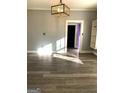 Bright living room showcasing gray walls, modern light fixture, and wood-look floors with a glimpse into another room at 2134 Main Nw St, Atlanta, GA 30318