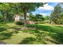 Charming two-story home with brick facade, red shutters, and well-maintained landscaping in a lush, green setting at 7121 Forest Se Dr, Covington, GA 30014
