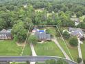 Aerial view of a home on a vast 1.1-acre lot, featuring a backyard pool, and long driveway at 704 Branchview Ct, Mcdonough, GA 30252