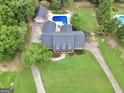 Aerial shot of a beautiful estate featuring a backyard pool, detached garage, and a sprawling lawn at 704 Branchview Ct, Mcdonough, GA 30252