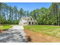 Side view of home with a long driveway leading up to the attached garage, surrounded by a green lawn at 1547 South Bethany Rd, Locust Grove, GA 30248