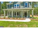 Inviting two-story home featuring a covered porch, manicured lawn and stylish black shutters at 1555 South Bethany Rd, Locust Grove, GA 30248