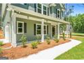 Inviting front porch with white columns and meticulously landscaped walkway at 1555 South Bethany Rd, Locust Grove, GA 30248