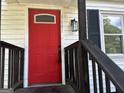 Close-up of the front door, painted in a striking red color with a charming porch light at 1681 Stanton Sw Rd, Atlanta, GA 30311
