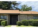 Well-maintained brick home with a brown roof, lush greenery, and inviting front entrance at 5526 Stoneleigh Court, Stone Mountain, GA 30088