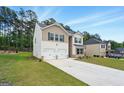 Well maintained home with a long driveway, manicured lawn, and a lush tree line in the background at 768 Great Oak Place # 26, Villa Rica, GA 30180