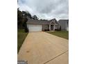 Inviting single-level home with a spacious driveway and manicured landscaping at 170 Forray Dr, Covington, GA 30016