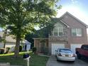 Beautiful brick home with a two-car garage and landscaped front yard, shaded by a mature tree at 11657 Flemming Ct, Hampton, GA 30228