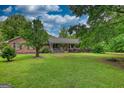 Inviting single-story brick home with a front porch, surrounded by mature trees and greenery at 78 N Pomona Rd, Hampton, GA 30228