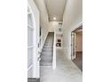Bright foyer with staircase and tile flooring leading into the home's main level at 365 Othello Dr, Hampton, GA 30228