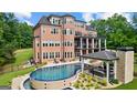 The outdoor pool with a covered patio, lounge area, and well-maintained landscaping at 4320 Blue Ridge Dr, Douglasville, GA 30135
