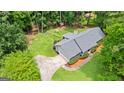 Aerial view of a home with a long driveway, lush landscaping, and mature trees at 145 Adams Ct, Fayetteville, GA 30214