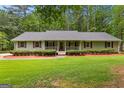 Inviting single-story home featuring a covered front porch, well-manicured lawn, and shrubbery at 145 Adams Ct, Fayetteville, GA 30214