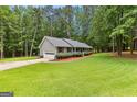 Well maintained home with a lush green lawn, mature trees, and an attached garage at 145 Adams Ct, Fayetteville, GA 30214