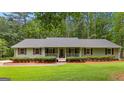 Inviting single-story home with a covered front porch, symmetrical design, and lush lawn at 145 Adams Ct, Fayetteville, GA 30214