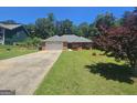 Beautiful single-story brick home with a lush green lawn and a paved driveway leading to the two-car garage at 212 Hunting Court, Jonesboro, GA 30236