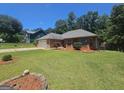 Well-maintained single-story brick home with a two-car garage and mature landscaping in the front yard at 212 Hunting Court, Jonesboro, GA 30236
